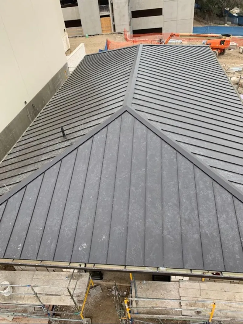 Commercial metal roof construction with crane equipment in Frederick